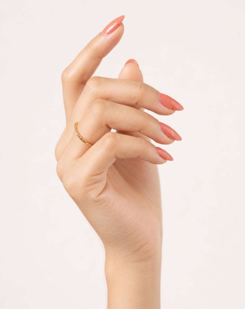 The same Make it NOD Coral Gloss press-on nail set worn on a light skin tone