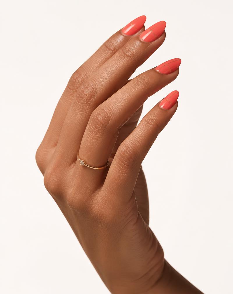The same Make it NOD Coral Gloss press-on nail set worn on a tan skin tone